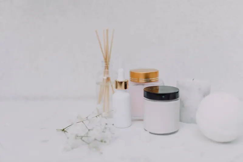 Elegant minimalistic display of skincare products and aromatherapy essentials on a clean white background