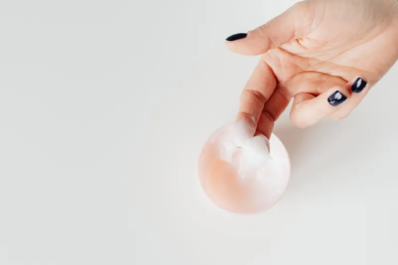A close-up view of a hand applying cream with neatly manicured nails, perfect for skincare concepts