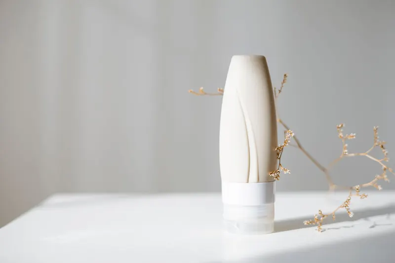 Elegant minimalist skincare bottle with dried branch, ideal for beauty and spa themes